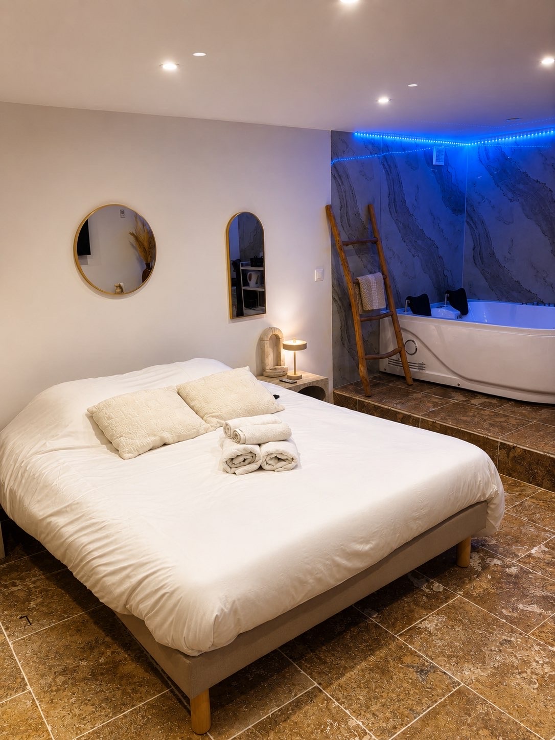 Lit et jacuzzi dans une ambiance néon de la suite Dolce Notte